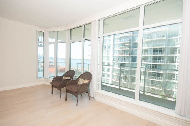 Bright living room with hardwood floors and city view. - 404 - 185 Victory Ship Way, North Vancouver