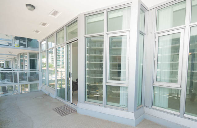Spacious living room with large windows and city views. - 404 - 185 Victory Ship Way, North Vancouver