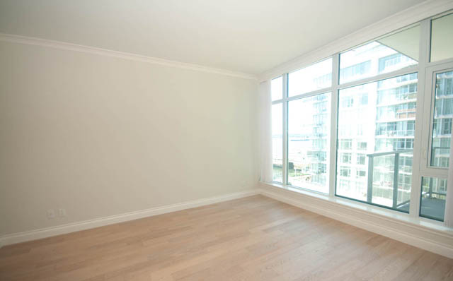 Bright living room with hardwood floors and city view. - 404 - 185 Victory Ship Way, North Vancouver