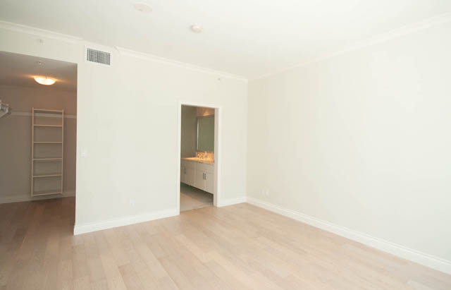 Bright living room with hardwood floors and white walls. - 404 - 185 Victory Ship Way, North Vancouver