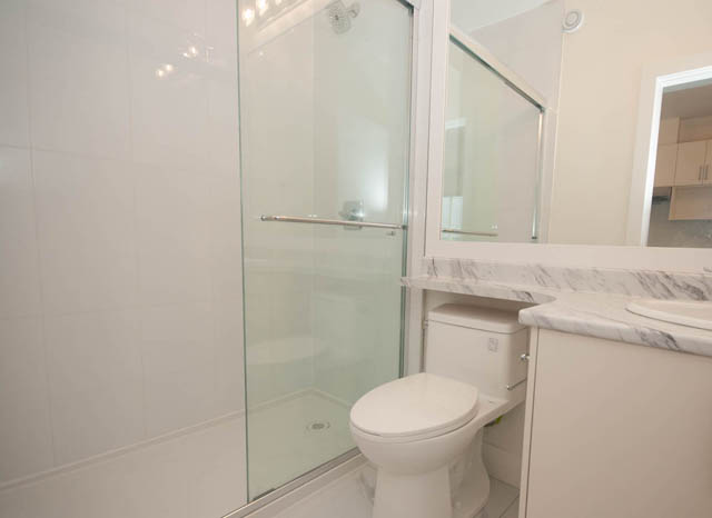 Bright bathroom with marble countertops and a glass shower. - 517 E 20th Ave, Vancouver East Side