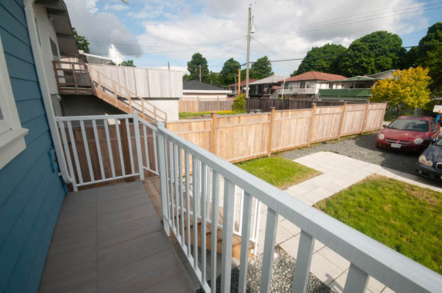 Balcony with wooden railings and view of fenced backyard. - 517 E 20th Ave, Vancouver East Side
