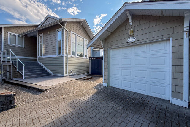 House exterior with brick driveway and white garage door. - 2307 Marine Drive, West Vancouver