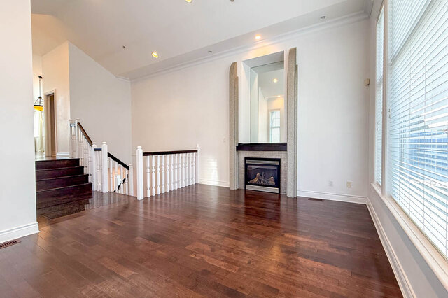 Spacious living room with rich hardwood floors and a fireplace, large windows with blinds. - 2307 Marine Drive, West Vancouver