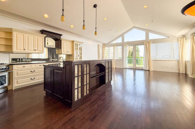 Bright kitchen with dark wood island, hardwood floors, and city view. - 2307 Marine Drive, West Vancouver