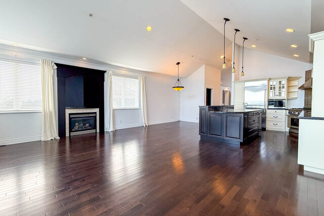 Spacious living area with rich hardwood floors and a cozy fireplace. - 2307 Marine Drive, West Vancouver