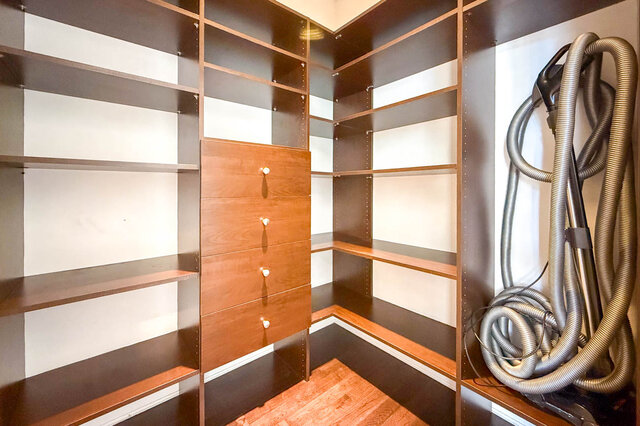 Walk-in closet with dark wood shelving and hardwood flooring. - 2307 Marine Drive, West Vancouver