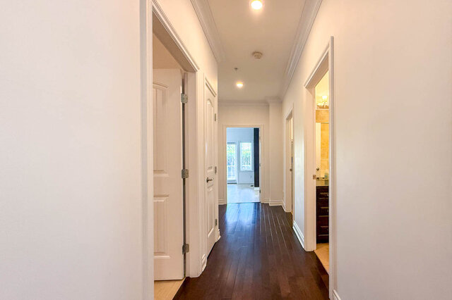 Bright hallway with dark hardwood floors and white paneled doors. - 2307 Marine Drive, West Vancouver