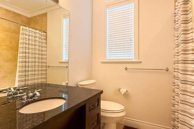 Bathroom with dark granite countertop and striped shower curtain. - 2307 Marine Drive, West Vancouver