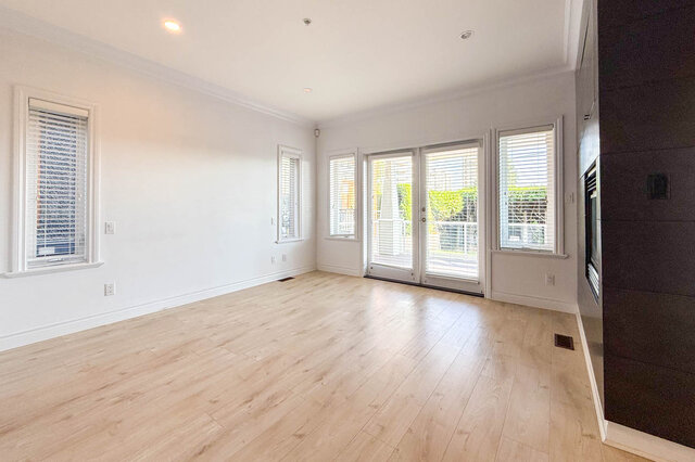 Bright living room with light hardwood floors and large windows with shutters. - 2307 Marine Drive, West Vancouver
