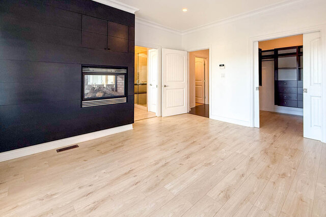 Spacious living room with dark accent wall fireplace and light hardwood floors. - 2307 Marine Drive, West Vancouver