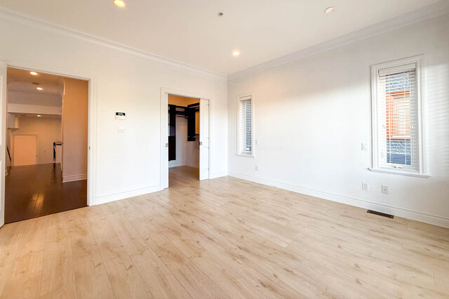 Spacious living room with light hardwood floors and large window with shutters. - 2307 Marine Drive, West Vancouver