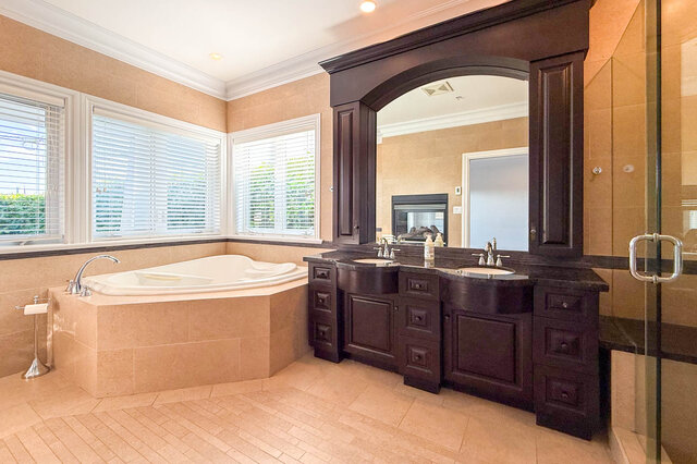 Spacious bathroom with dark wood vanity and corner whirlpool tub. - 2307 Marine Drive, West Vancouver
