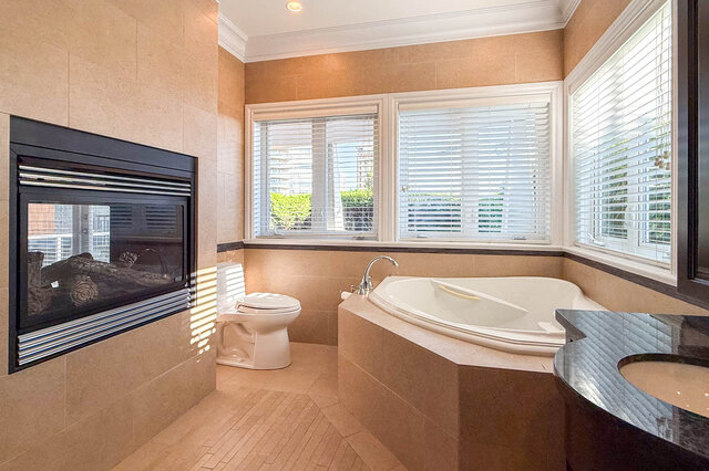 Spacious bathroom with modern fireplace and large windows with shutters. - 2307 Marine Drive, West Vancouver