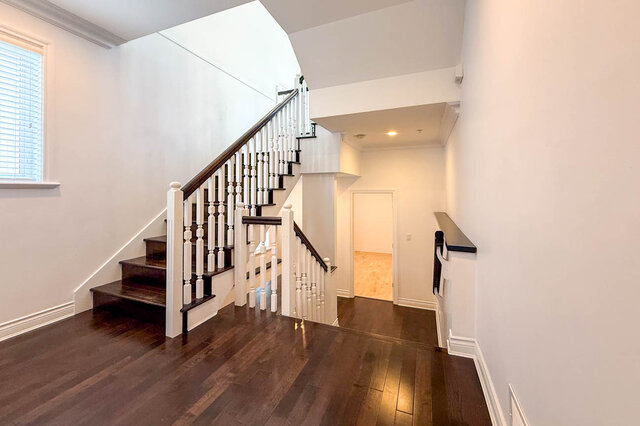 Staircase foyer with dark hardwood floors and white balustrade. - 2307 Marine Drive, West Vancouver
