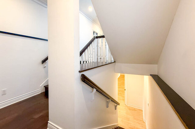 Staircase landing with dark hardwood floors and white railing. - 2307 Marine Drive, West Vancouver