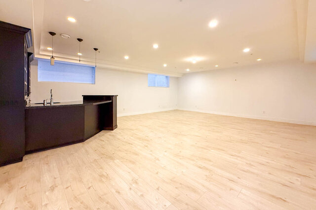 Spacious open-concept kitchen with sleek black countertops and light hardwood floors. - 2307 Marine Drive, West Vancouver