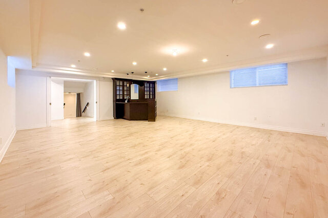 Spacious living area with light hardwood floors and built-in bar. - 2307 Marine Drive, West Vancouver
