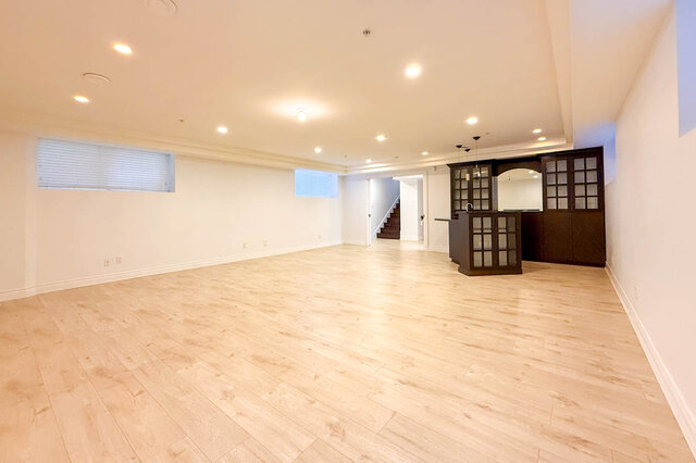 Spacious living area with light hardwood floors and a built-in glass-front bar. - 2307 Marine Drive, West Vancouver