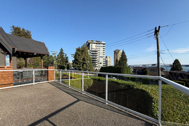 Balcony with white railing and city view of high-rises and greenery. - 2307 Marine Drive, West Vancouver