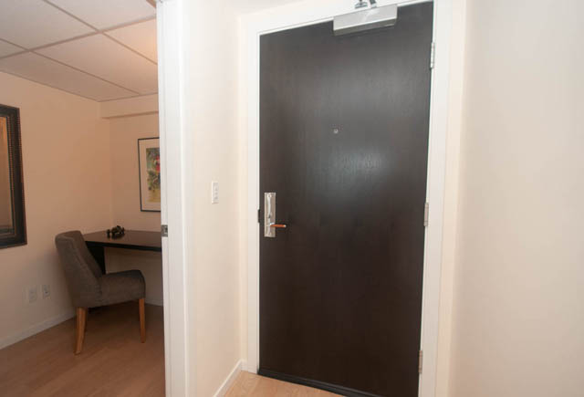 Furnished living room with hardwood floors and a dark door. - 3301 - 1351 Continental Street, Vancouver Downtown