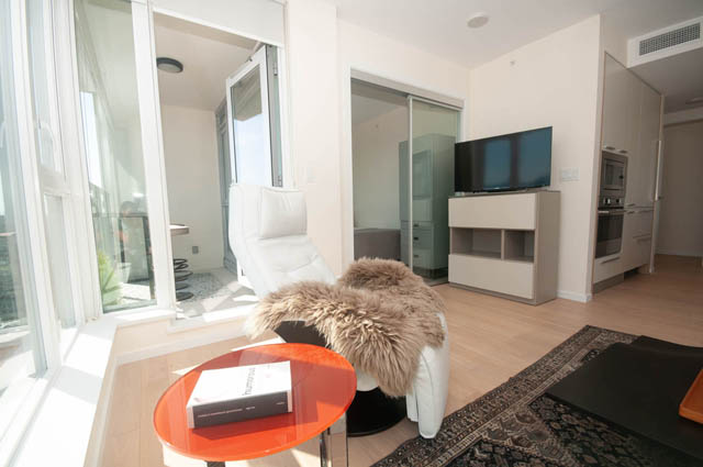 Bright living room with hardwood floors, modern furniture, and a city view. - 3301 - 1351 Continental Street, Vancouver Downtown