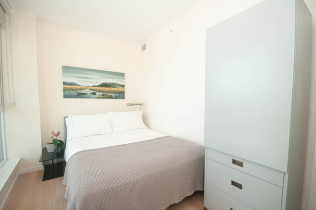 Furnished 2-bedroom + den with a cozy sofa and a large painting of a serene landscape. - 3301 - 1351 Continental Street, Vancouver Downtown