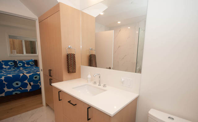 Furnished bathroom with white countertops and wooden cabinets. - 114 West 14th Ave, Vancouver West Side