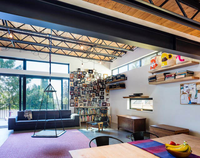 Bright living room with exposed beams, bookshelves, and a swing chair. - Address WITHHELD, North Vancouver