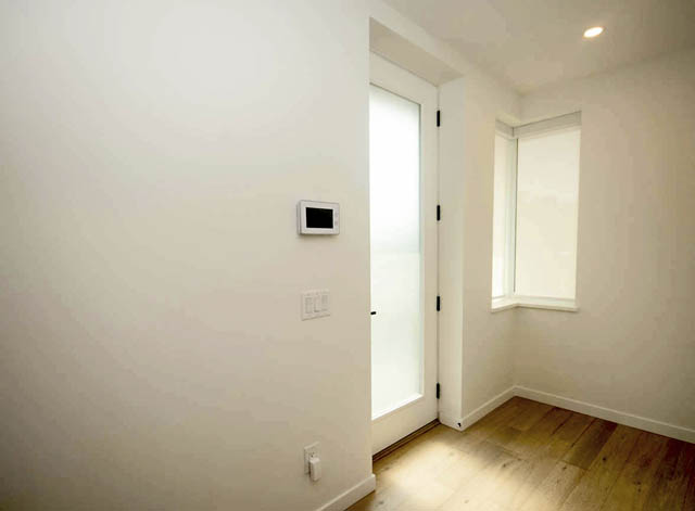 Spacious bedroom with hardwood floors and a sliding glass door leading to a balcony. - 9 - 528 East 2nd, North Vancouver