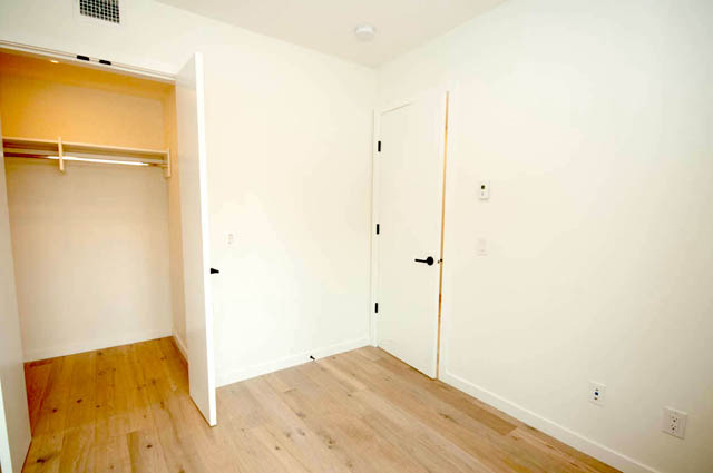 Spacious bedroom with hardwood floors and a closet. - 9 - 528 East 2nd, North Vancouver