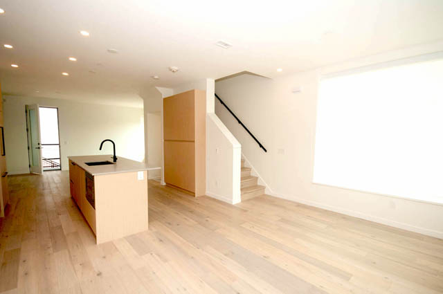 Spacious living room with hardwood floors and modern kitchen island. - 9 - 528 East 2nd, North Vancouver