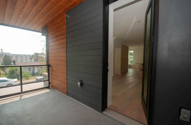 Spacious balcony with wooden ceiling, hardwood floors, and city view. - 9 - 528 East 2nd, North Vancouver