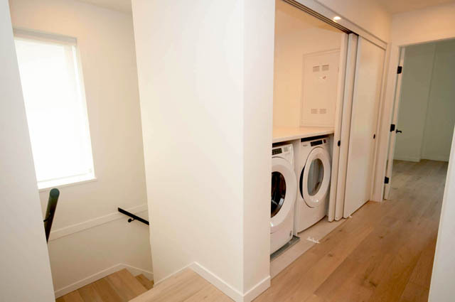 Bright laundry room with sliding doors and hardwood floors. - 9 - 528 East 2nd, North Vancouver