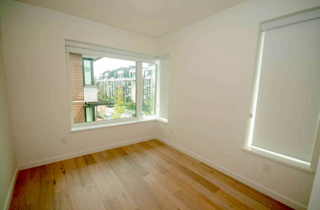 Spacious corner bedroom with hardwood floors and a city view. - 9 - 528 East 2nd, North Vancouver