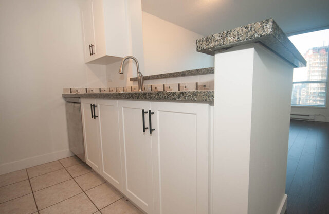 Bright kitchen with granite countertops, white cabinetry, and a city view. - 1907 - 1420 West Georgia Street, Vancouver Downtown