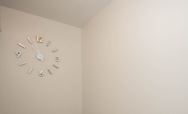 Spacious bedroom with minimalist wall clock and neutral tones. - 1907 - 1420 West Georgia Street, Vancouver Downtown