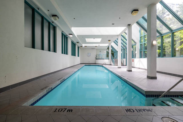 Spacious indoor pool area with tiled flooring and natural light from large windows. - 2607 - 939 Homer St, Vancouver Downtown