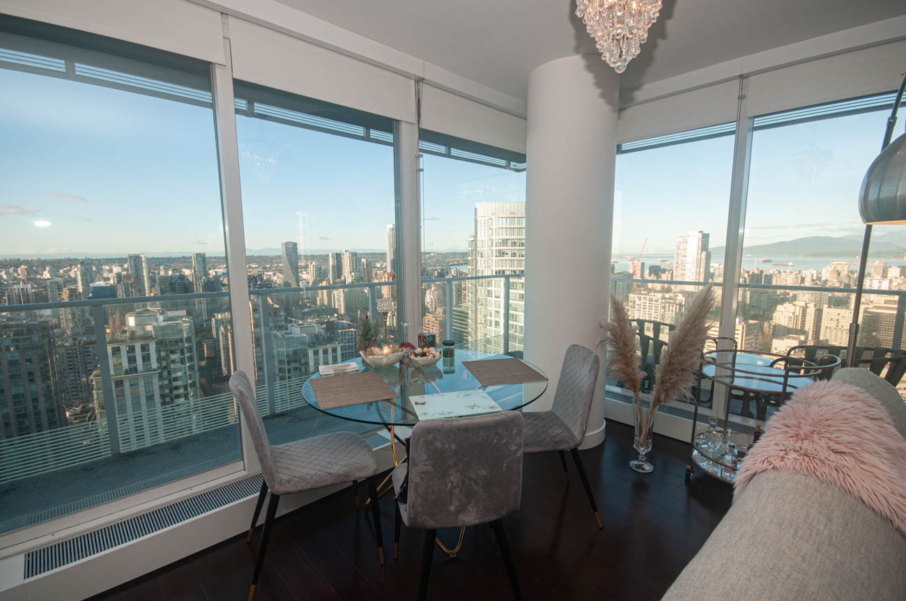 Bright dining area with panoramic city view and modern furnishings. - 4502 - 777 Richards St, Vancouver Downtown