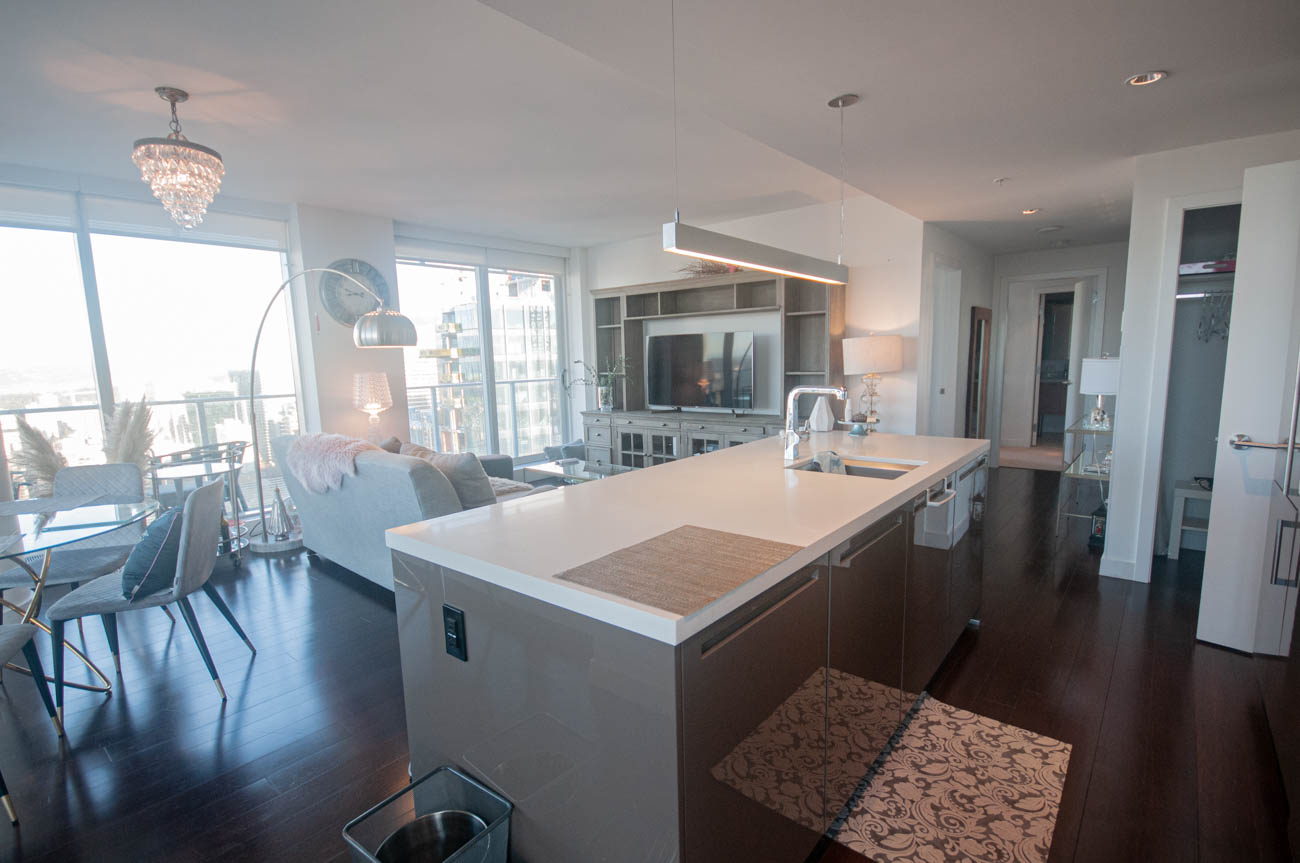 Bright kitchen with white countertops and hardwood floors, showcasing a city view. - 4502 - 777 Richards St, Vancouver Downtown