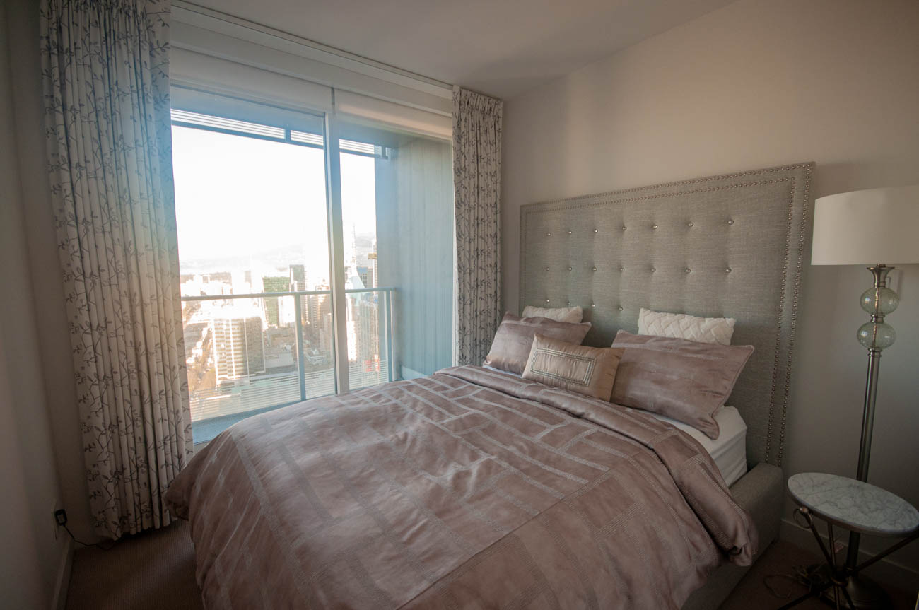 Furnished 2-bedroom condo with a city view and a tufted headboard bed. - 4502 - 777 Richards St, Vancouver Downtown