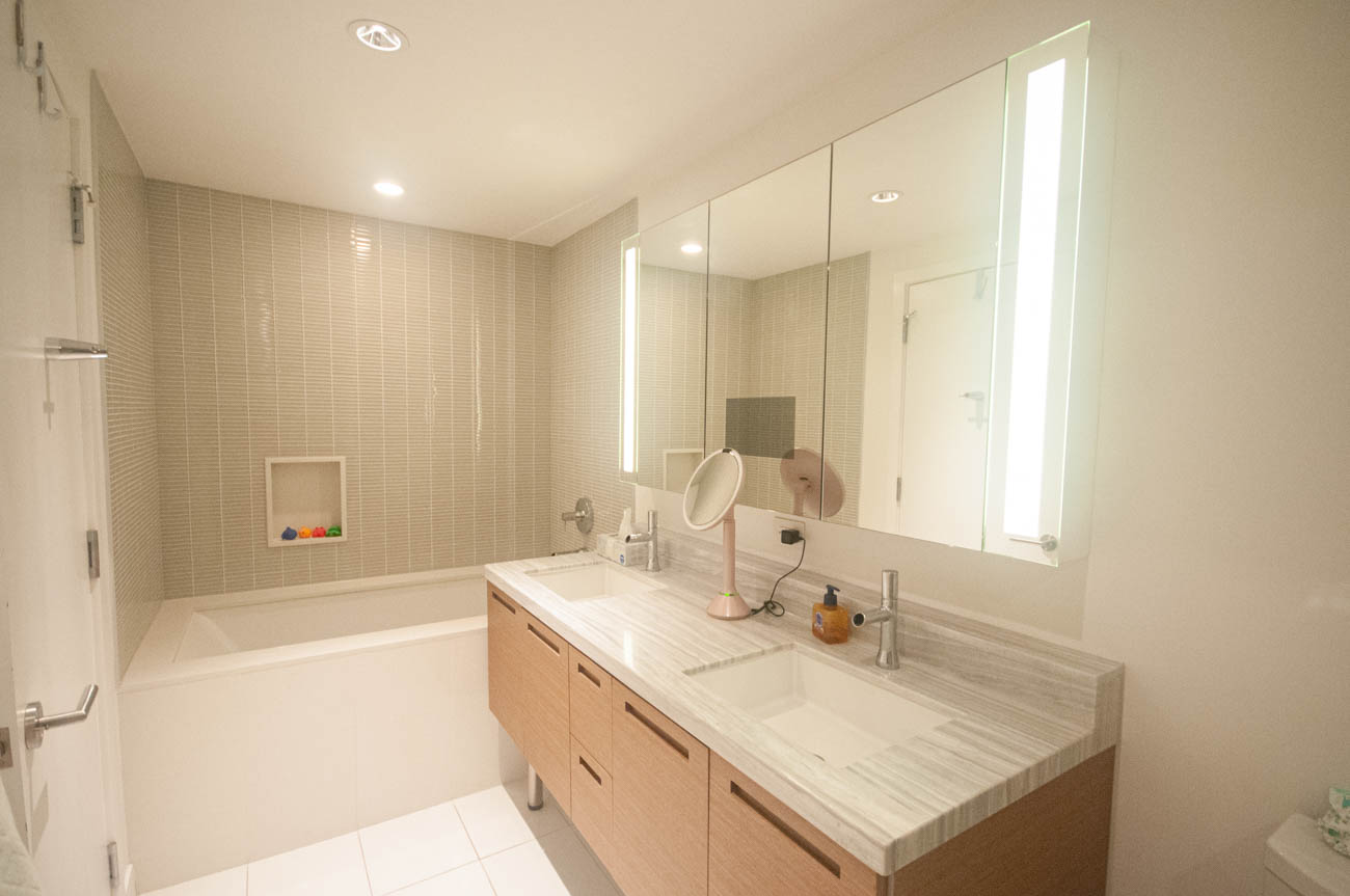 Bright bathroom with modern vanity, large mirror, and sleek countertop. - 4502 - 777 Richards St, Vancouver Downtown