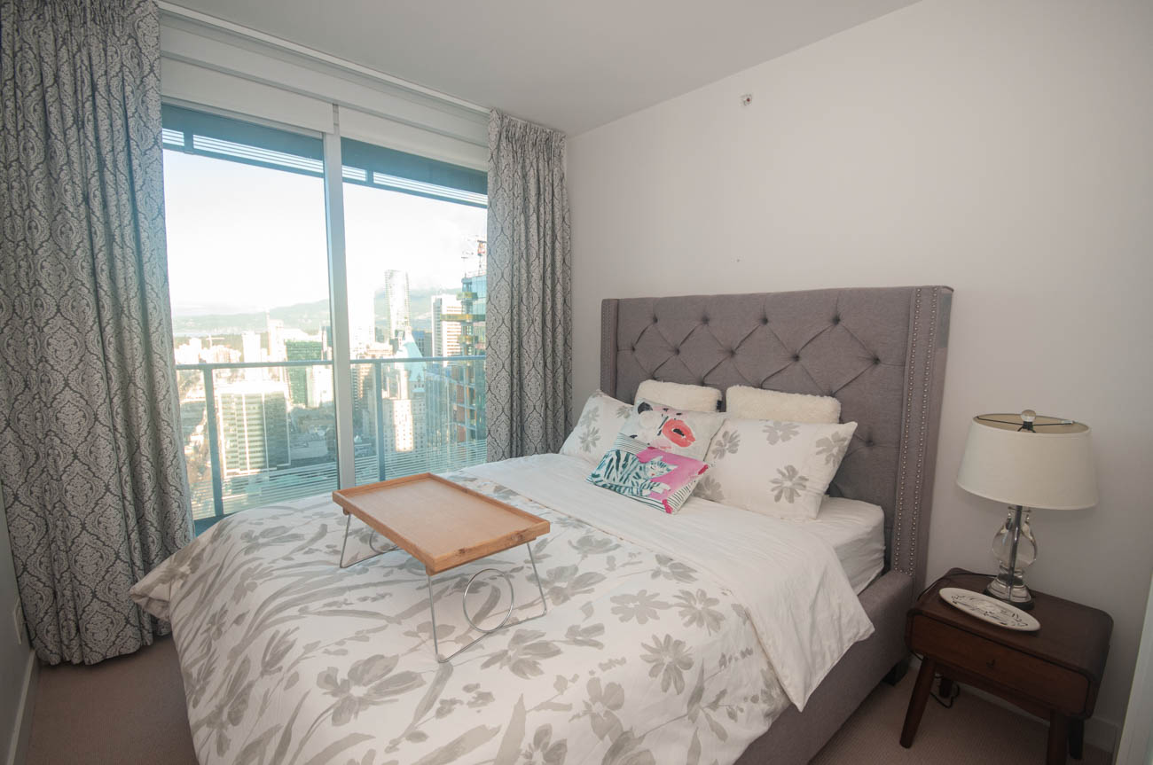 Bright bedroom with city view and tufted headboard. - 4502 - 777 Richards St, Vancouver Downtown