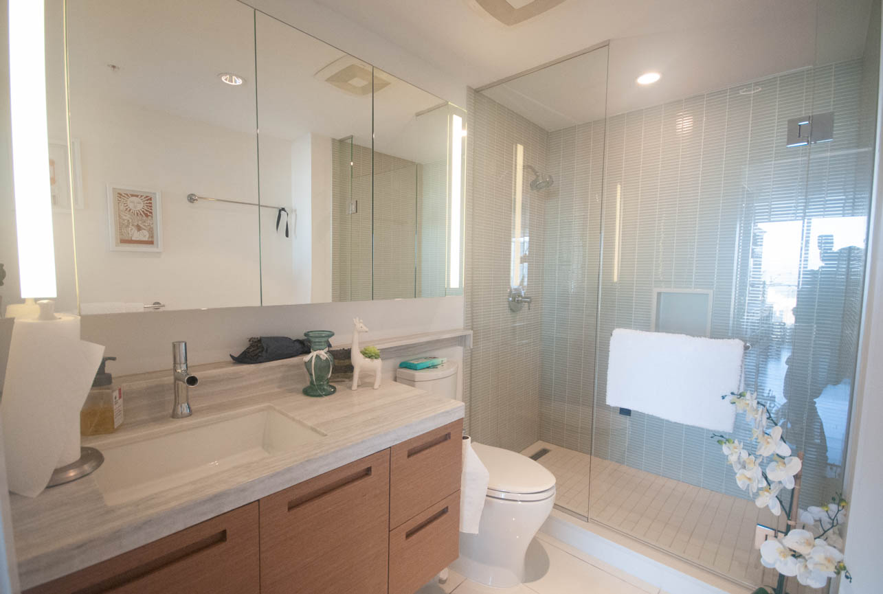 Furnished bathroom with large mirror, modern vanity, and glass shower. - 4502 - 777 Richards St, Vancouver Downtown