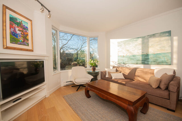 Spacious living room with hardwood floors, large bay windows, and a cozy sofa set. - 308 - 1688 Cypress Street, Vancouver West Side