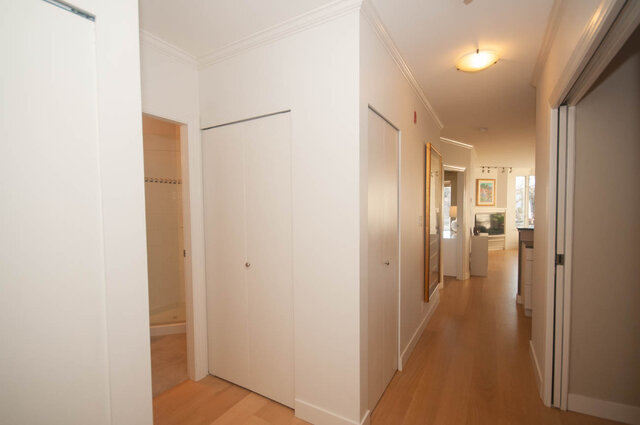 Spacious hallway with hardwood floors and modern closet doors, leading to a cozy living area. - 308 - 1688 Cypress Street, Vancouver West Side