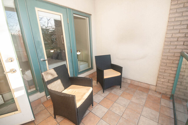 Furnished patio with two wicker chairs and a small table, perfect for relaxing. - 308 - 1688 Cypress Street, Vancouver West Side