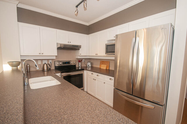 Bright kitchen with granite countertops, stainless steel appliances, and white cabinetry. - 308 - 1688 Cypress Street, Vancouver West Side
