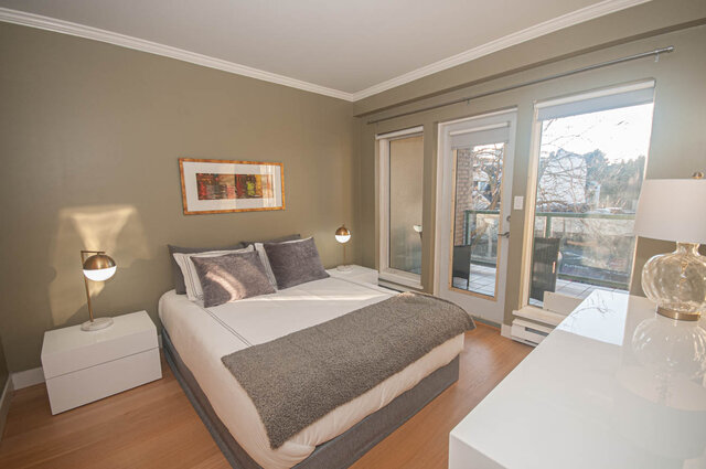 Spacious bedroom with hardwood floors, modern furnishings, and a city view. - 308 - 1688 Cypress Street, Vancouver West Side