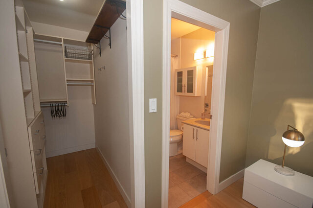 Spacious walk-in closet with built-in shelves and a cozy bathroom featuring a sink and light fixture. - 308 - 1688 Cypress Street, Vancouver West Side